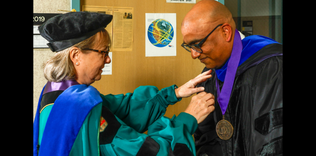 UIC Provost and Vice Chancellor for Academic Affairs Karen Colley pins a medal on ChE Professor and Department Head Vikas Berry at the investiture ceremony.